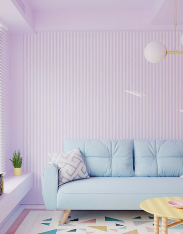 Light blue tufted froyo sofa with wooden legs and geometric throw pillow against striped wallpaper background