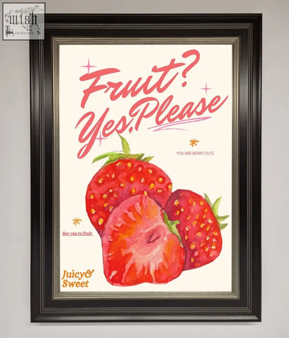 A framed poster with vibrant red strawberries and pink cursive fruit yes please text on a cream background