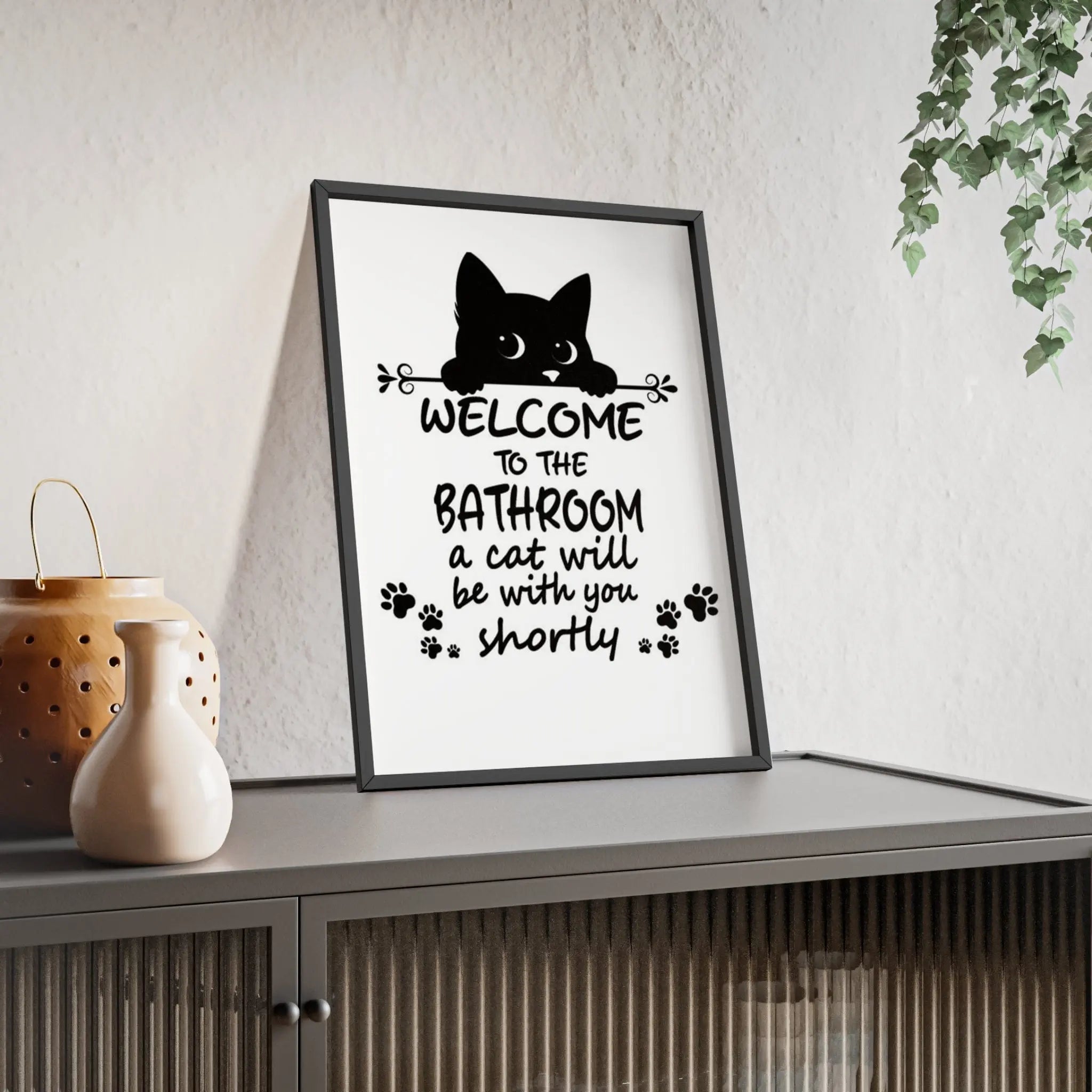 Black framed funny cat bathroom print with cat silhouette and welcome to the bathroom text with paw prints
