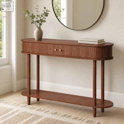 Warm brown wooden console table with curved top, vertical slat drawer, brass knobs, and sliding tambour doors