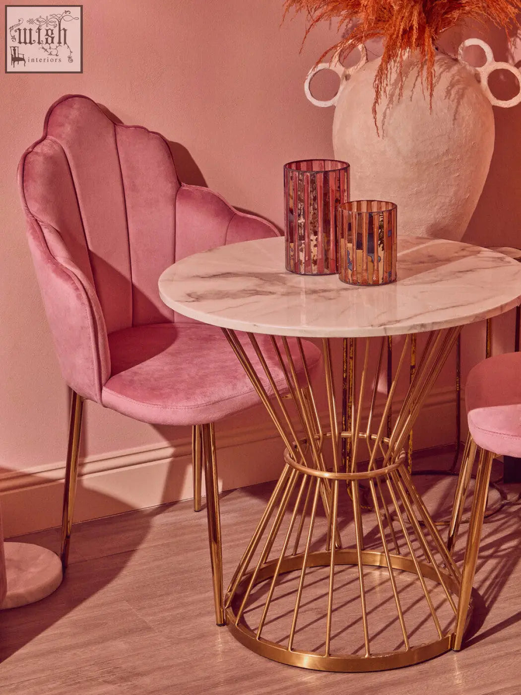 Pink velvet shell chair with gold metal legs beside a gaia pink large candle holder for stylish decor