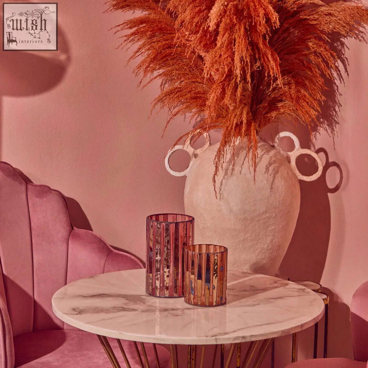A pair of rose gold metallic gaia pink mosaic small candle holders with vertical stripes on a marble table