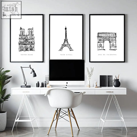 Three framed black-and-white paris landmarks wall art prints hang above a white desk in a gallery wall framing set