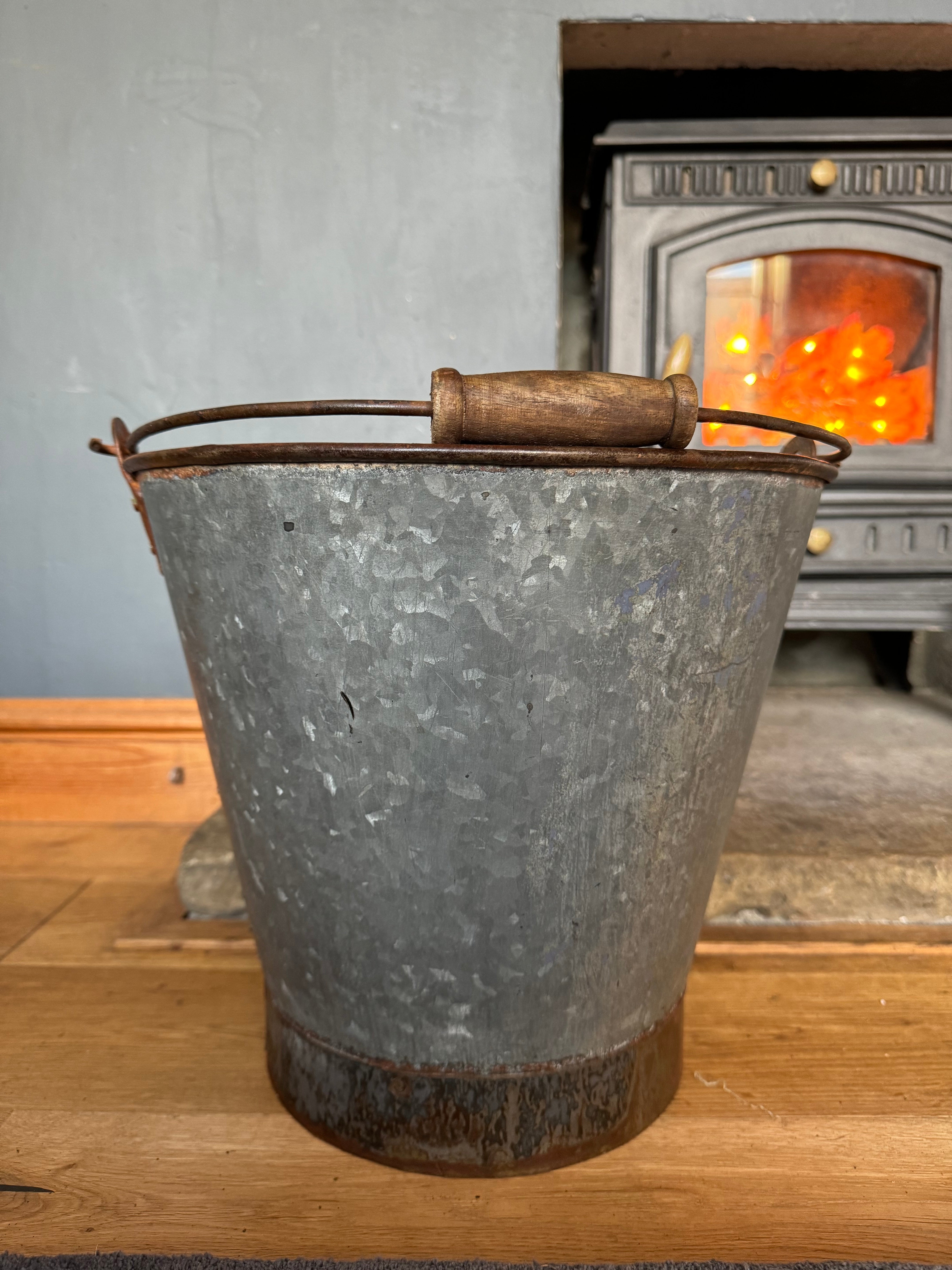 Galvanized metal log basket with wooden handle and rusted base perfect for christmas tree or plant pot use