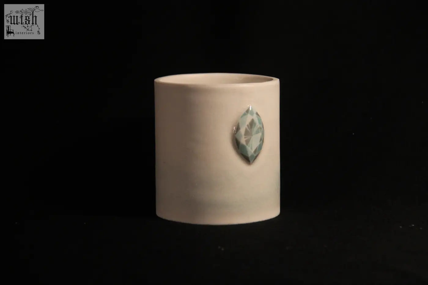 Cream-colored ceramic mug features five faceted teal gemstone accent in a sleek cylindrical design called gem mug