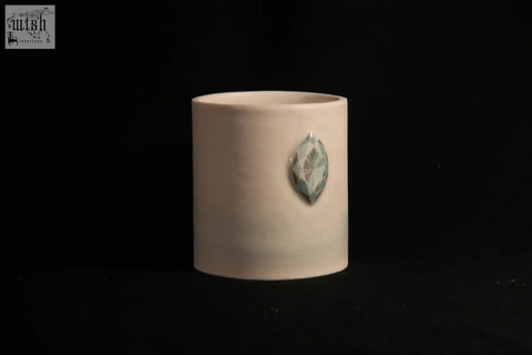 Cream-colored ceramic mug features five faceted teal gemstone accent in a sleek cylindrical design called gem mug