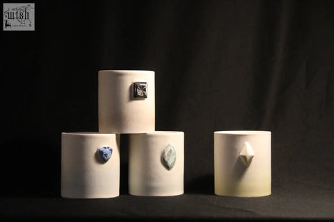 Cream-colored ceramic gem mug features five unique gemstone accents on cylindrical vases for stylish drinkware