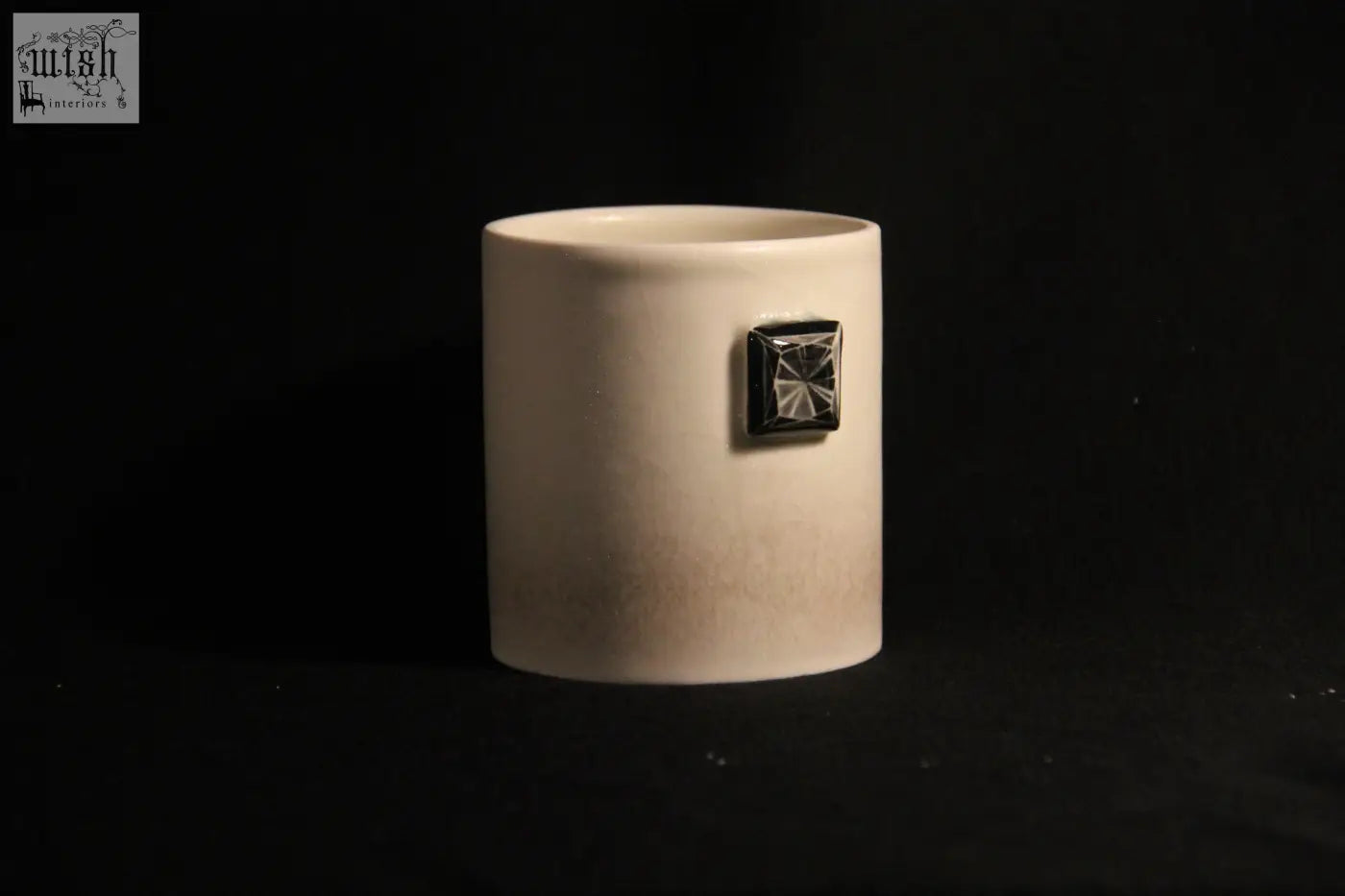 Cream-colored ceramic gem mug features five with a unique square faceted black accent on its side