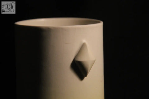 A minimalist white ceramic gem mug features five subtle geometric diamond-shaped reliefs on its side