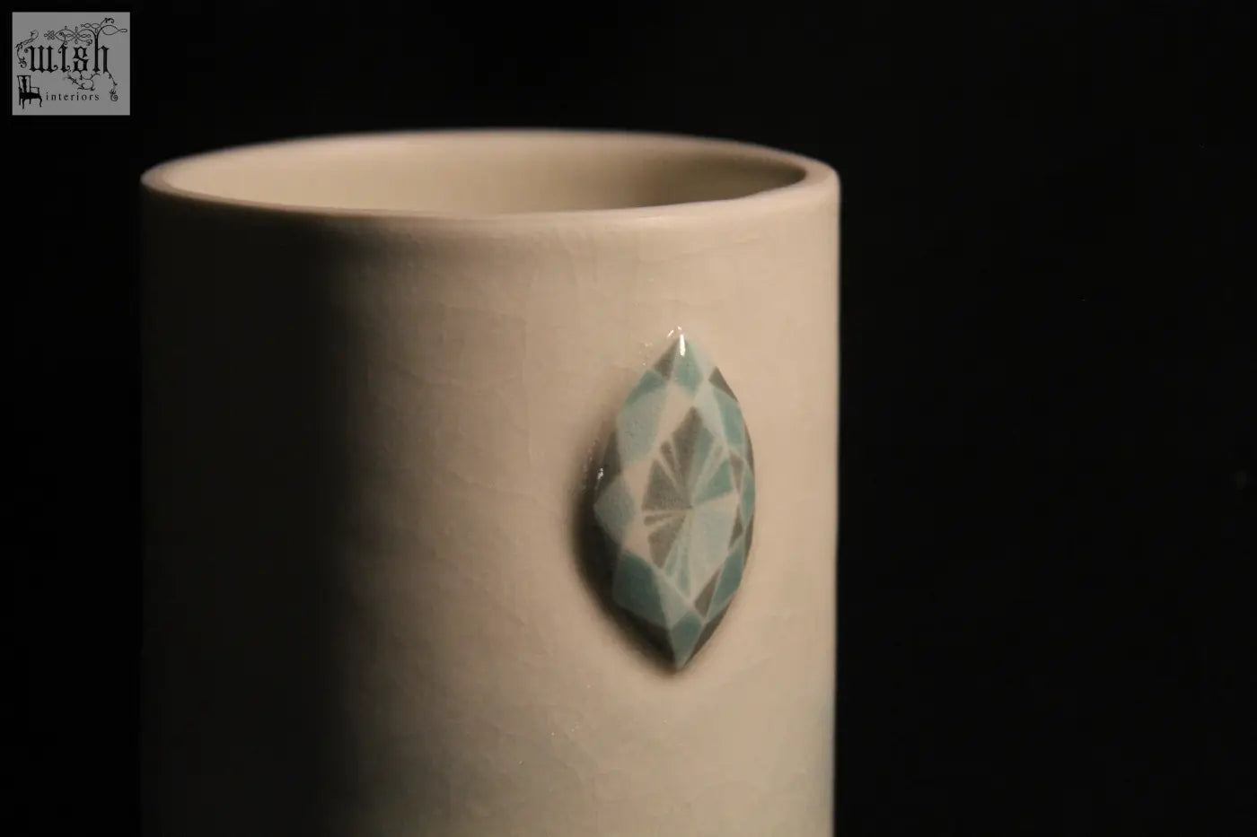 A white ceramic gem mug features five light blue faceted gemstone accents for a stylish drinkware look