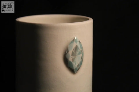 A white ceramic gem mug features five light blue faceted gemstone accents for a stylish drinkware look