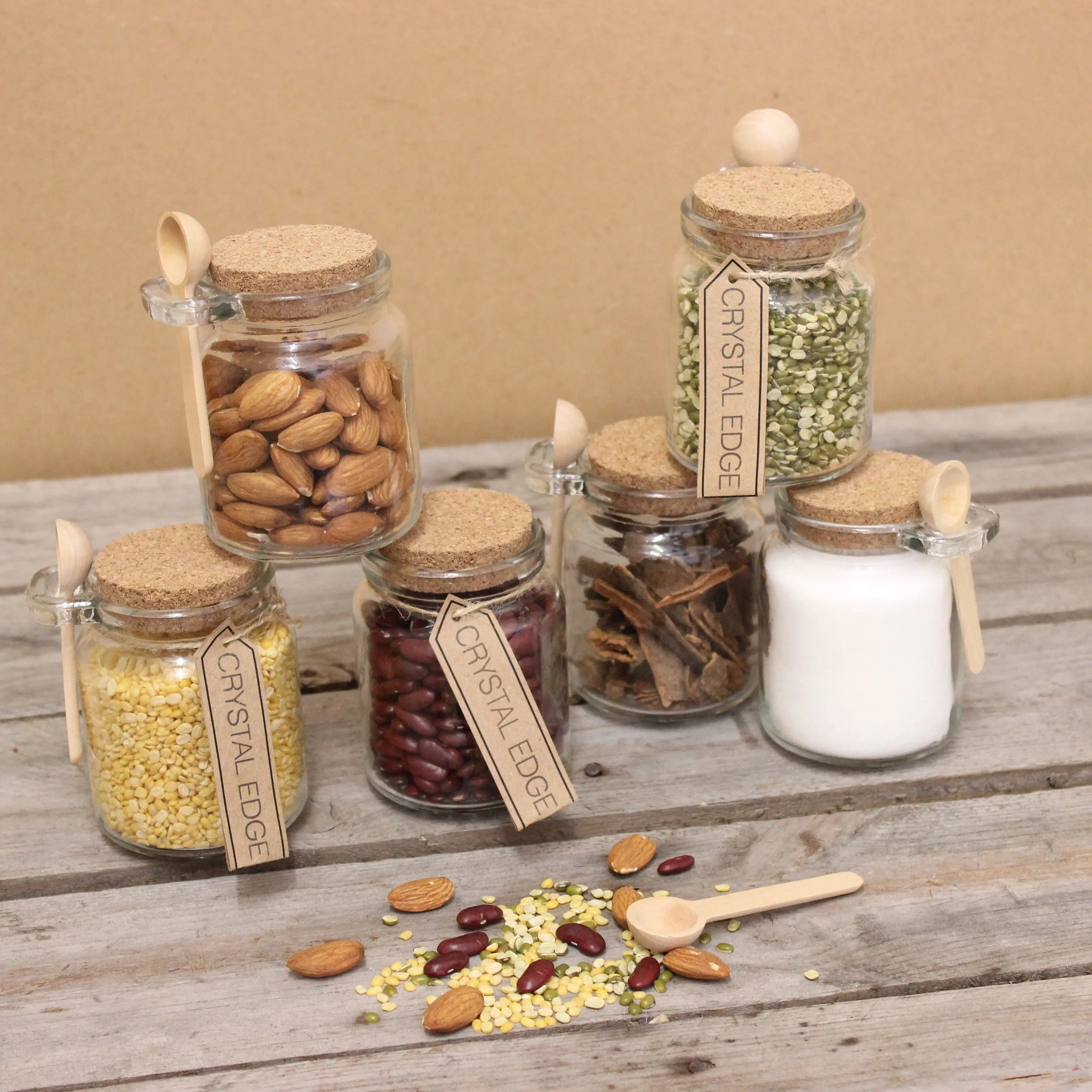Clear glass jars with cork stoppers and wooden spoons in a general store set of 6 for storing dried legumes and nuts