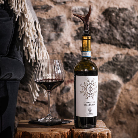 A dark green bottle of la masseria del rosso primitivo manduria wine sealed with a genuine roe antler bottle stopper