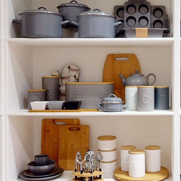 Gray enamel-coated geome grey bread bin in stoneware with lid and side handles neatly placed on top shelf