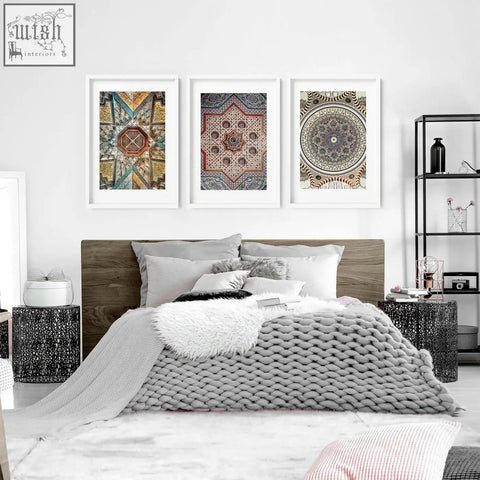 Gray knitted throw blanket with chunky weave draped on bed next to geometric patterns art prints for bedroom walls
