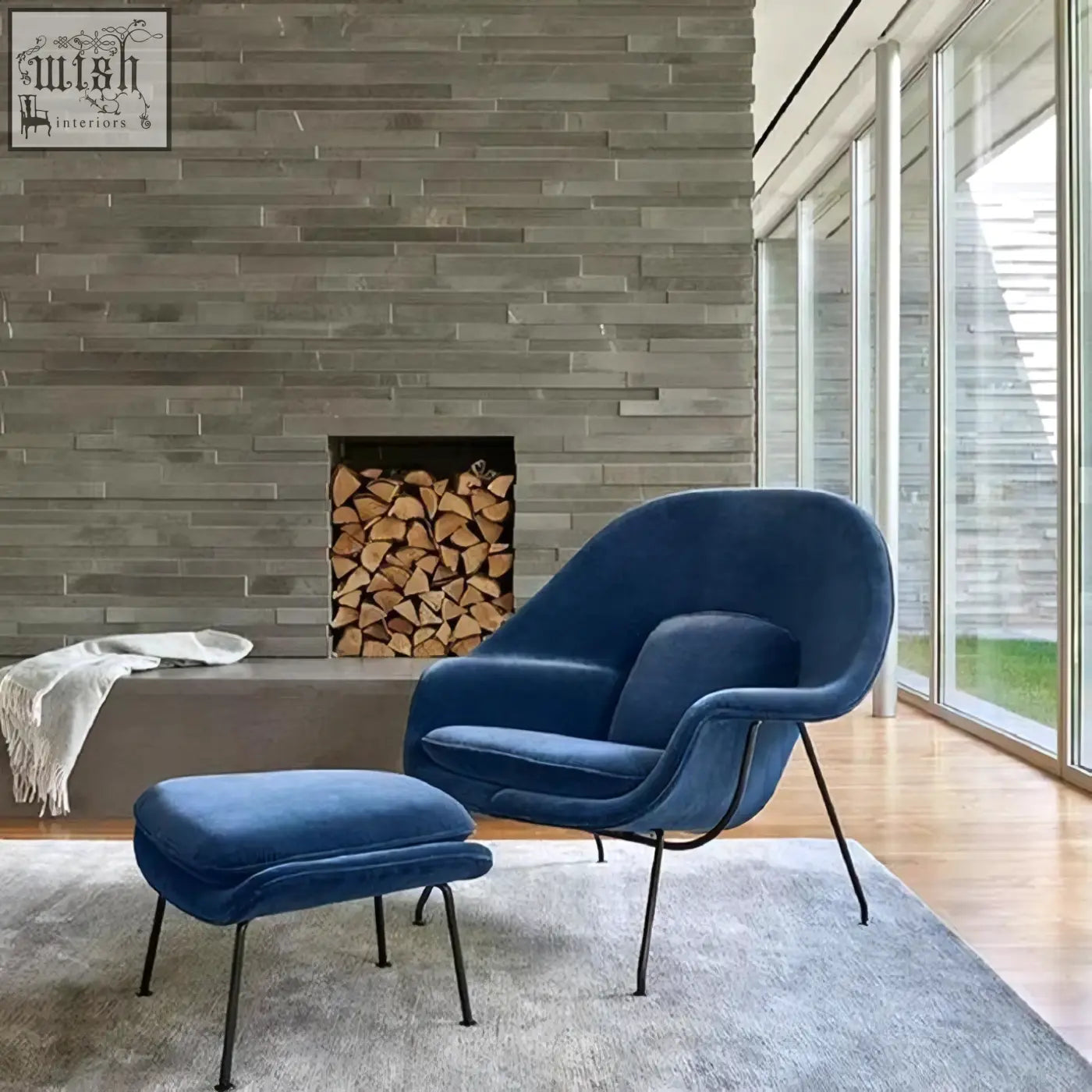 Deep blue velvet george womb chair with black metal legs and matching ottoman for cozy seating