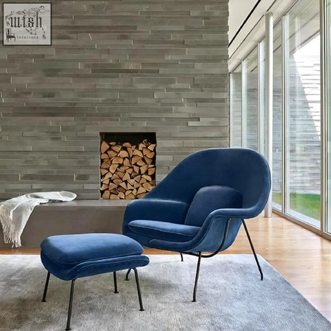 Deep blue velvet george womb chair with black metal legs and matching ottoman for cozy seating