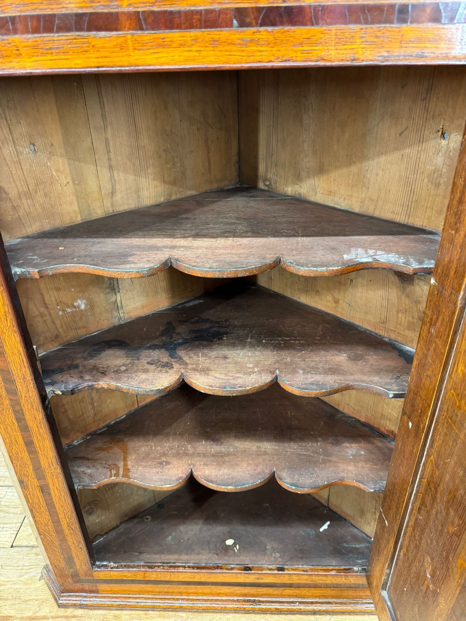 Antique georgian oak corner cupboard with scalloped shelves and polished amber finish for hall storage