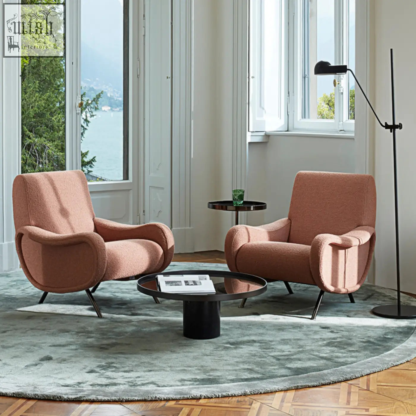 Two blush pink linen georgios lounge chairs with curved minimalist design and black metal legs perfect for lounging