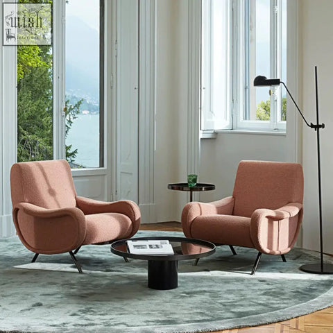 Two blush pink linen georgios lounge chairs with curved ergonomic design and black metal legs perfect for lounges