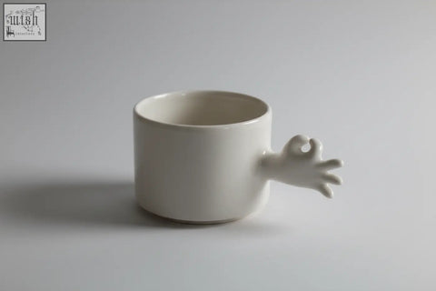 White ceramic mug from 4am product design cups series with a sculpted okay hand handle handmade porcelain coffee cup
