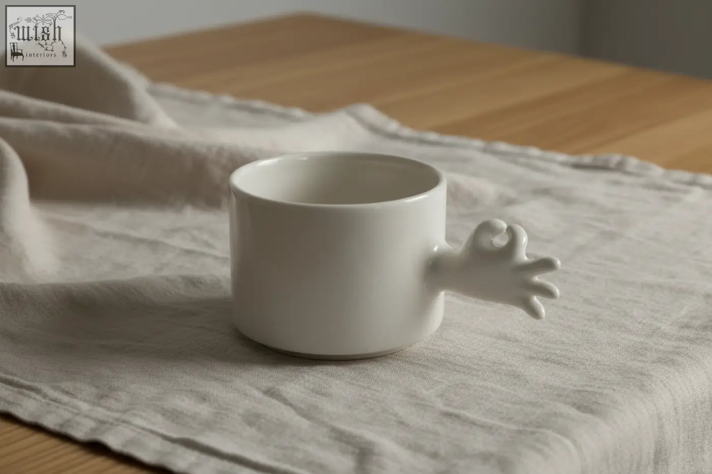 White ceramic mug with a sculpted hand-shaped handle from the 4am product design cups series handmade porcelain coffee cup