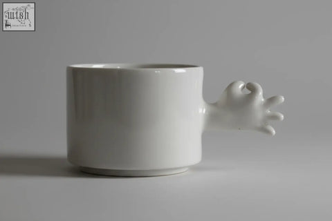 White ceramic handmade porcelain coffee cup with sculpted hand handle from the 4am product design cups series