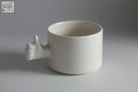 White ceramic handmade porcelain coffee cup with thumb-up handle from 4am product design cups series