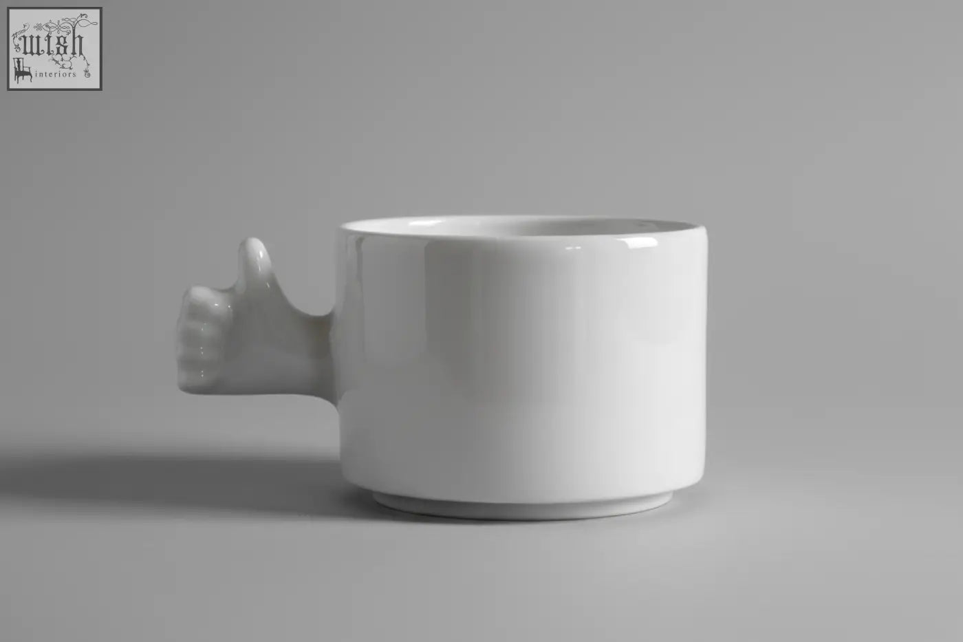 White ceramic mug with a sculpted thumb up hand handle from 4am product design cups series porcelain coffee cup