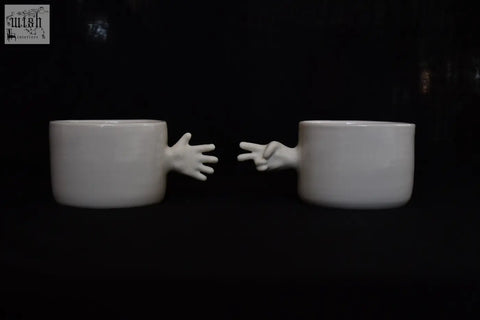 White ceramic porcelain coffee cups with sculpted hands making peace sign and open palm by 4am product design