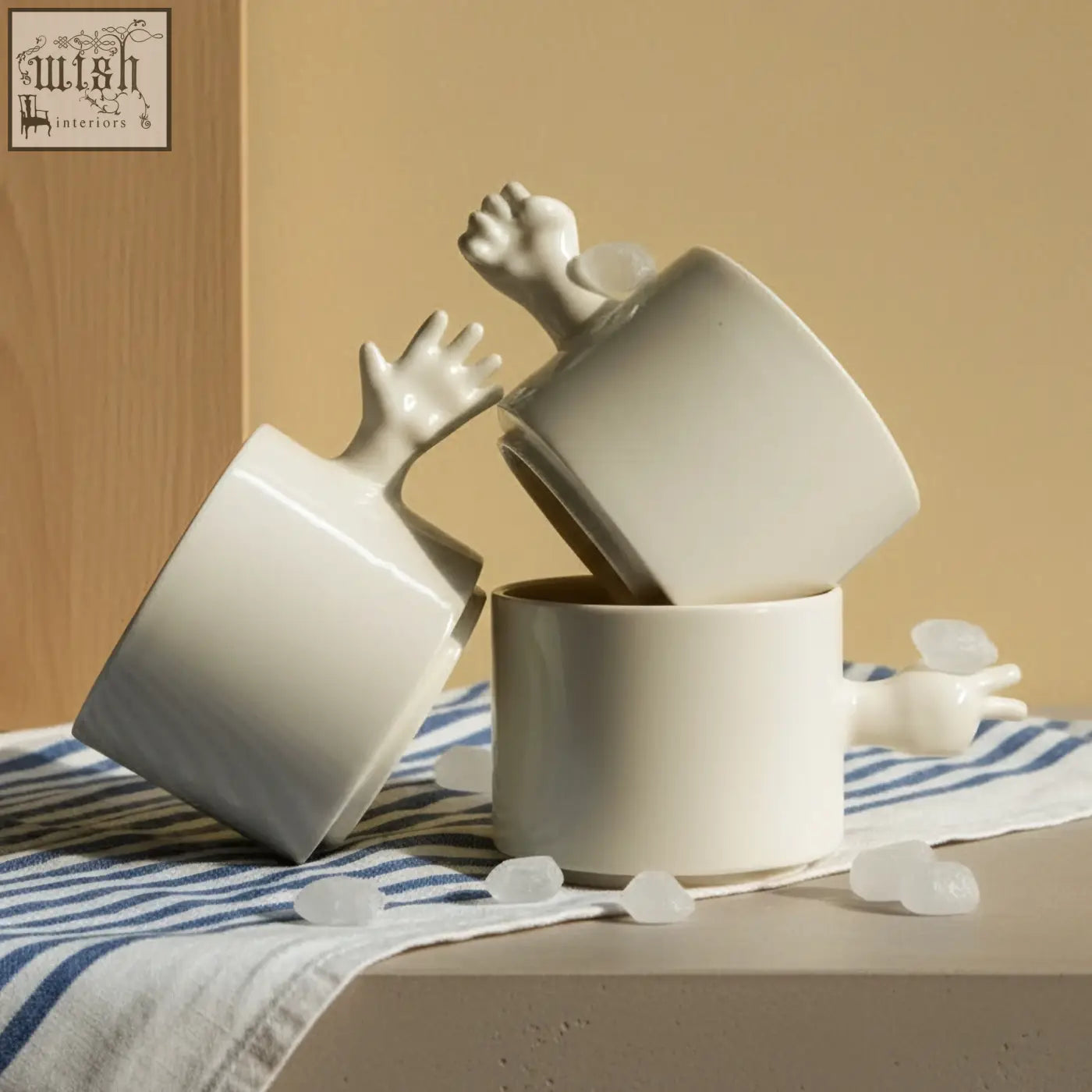 White ceramic mugs with sculpted hand handles stacked playfully made of porcelain in 4am product design set