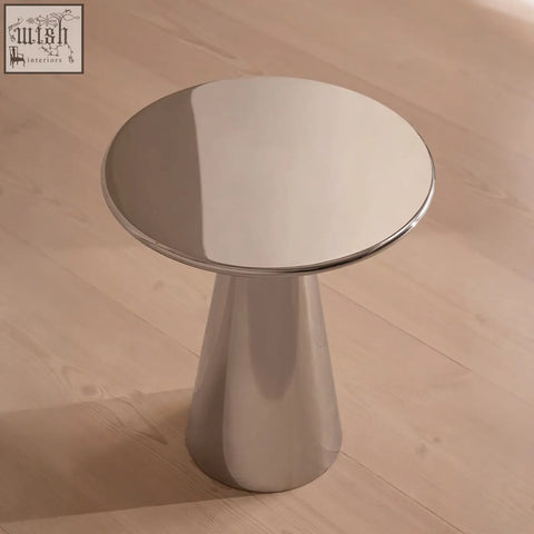 Shiny chrome finished ghosh side table with circular top and sleek minimalist design in stainless steel