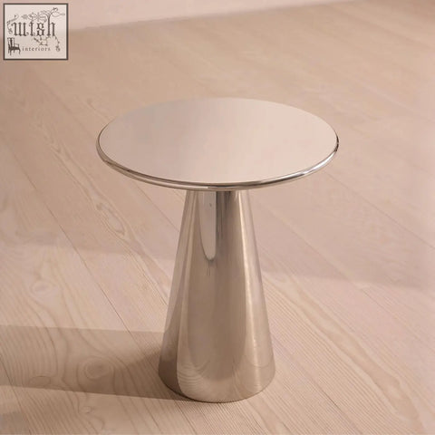 A sleek ghosh side table with a round polished chrome top and stainless steel tapered conical base