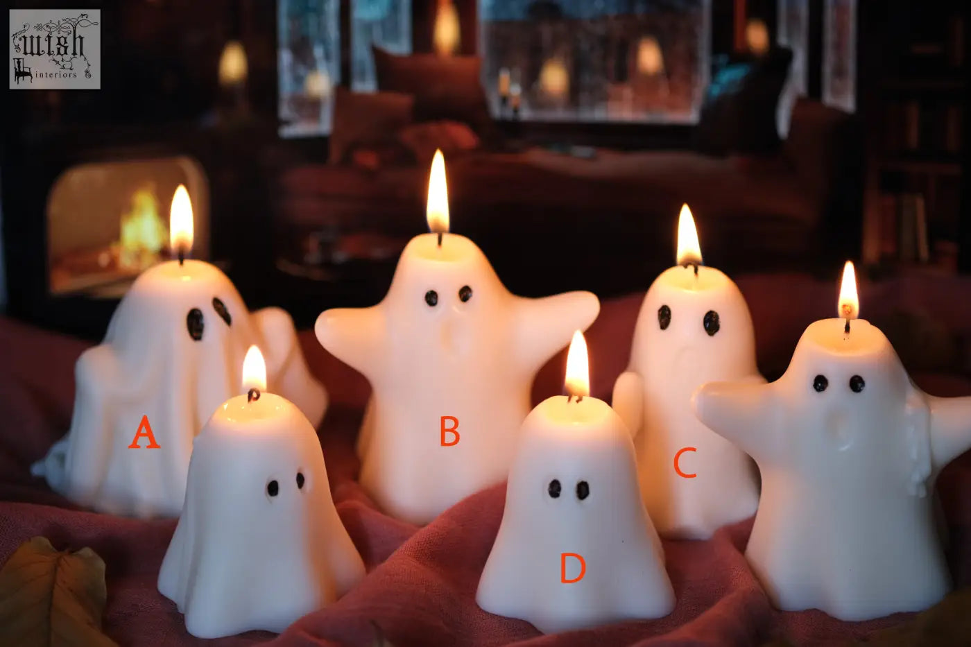 White ghost-shaped halloween candles with black dot eyes and lit wicks perfect for pumpkin spiced fall vibes