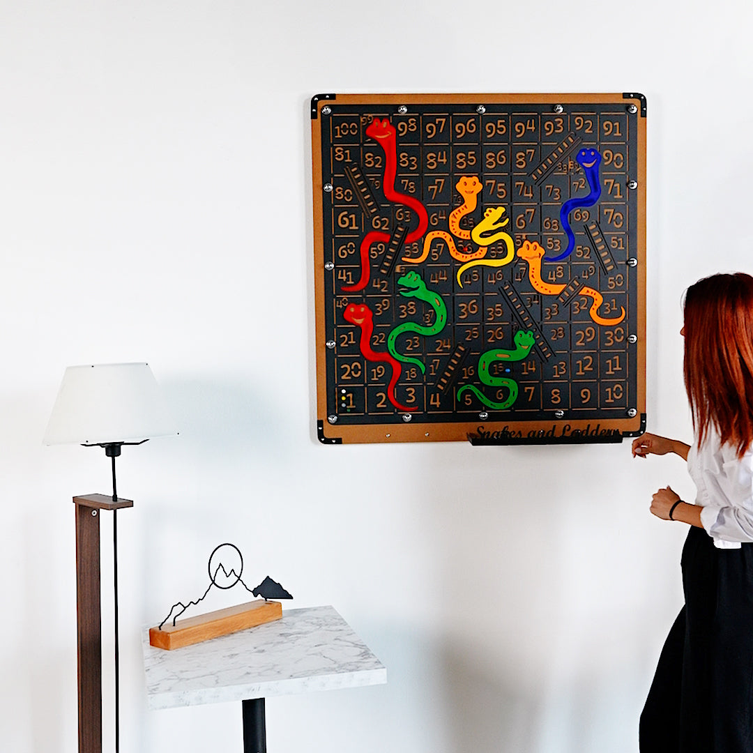 Giant snakes and ladders game board with colorful red green yellow blue and orange snakes and ladders on wooden frame