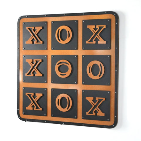 A rustic metal tic tac toe wall art with bold orange x o in a black grid framed by aged copper giant xox board
