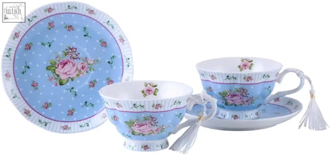 Delicate porcelain tea set with blue rose patterned cups saucers and milk jug on a special 3 tier cake stand