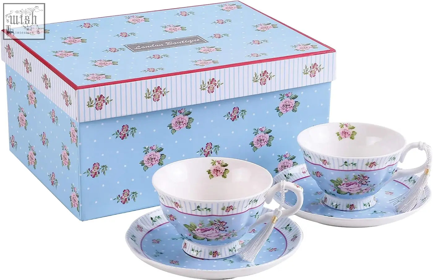 A delicate porcelain teacup and saucer with pink flowers on light blue in a gift set with milk jug and tier cake stand