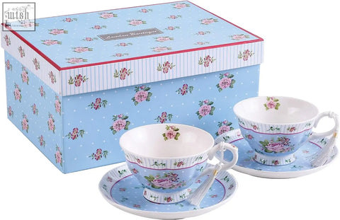 A delicate porcelain teacup and saucer with pink flowers on light blue in a gift set with milk jug and tier cake stand