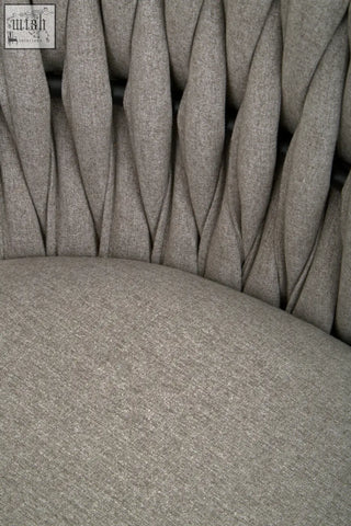 Gray dining chair with tufted woven fabric and vertical pleats showing the back side texture and design