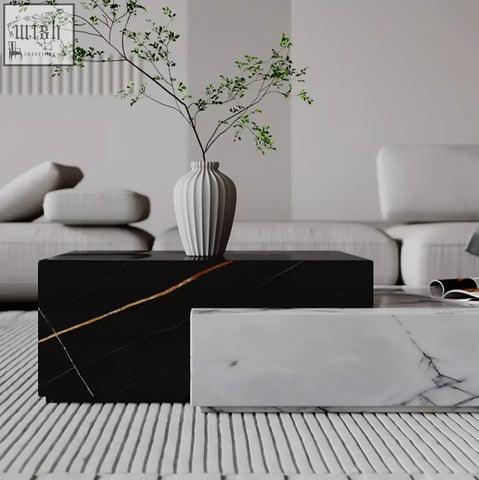 A sleek white ceramic vase with green branches on a stone giuli marble coffee table set centerpiece