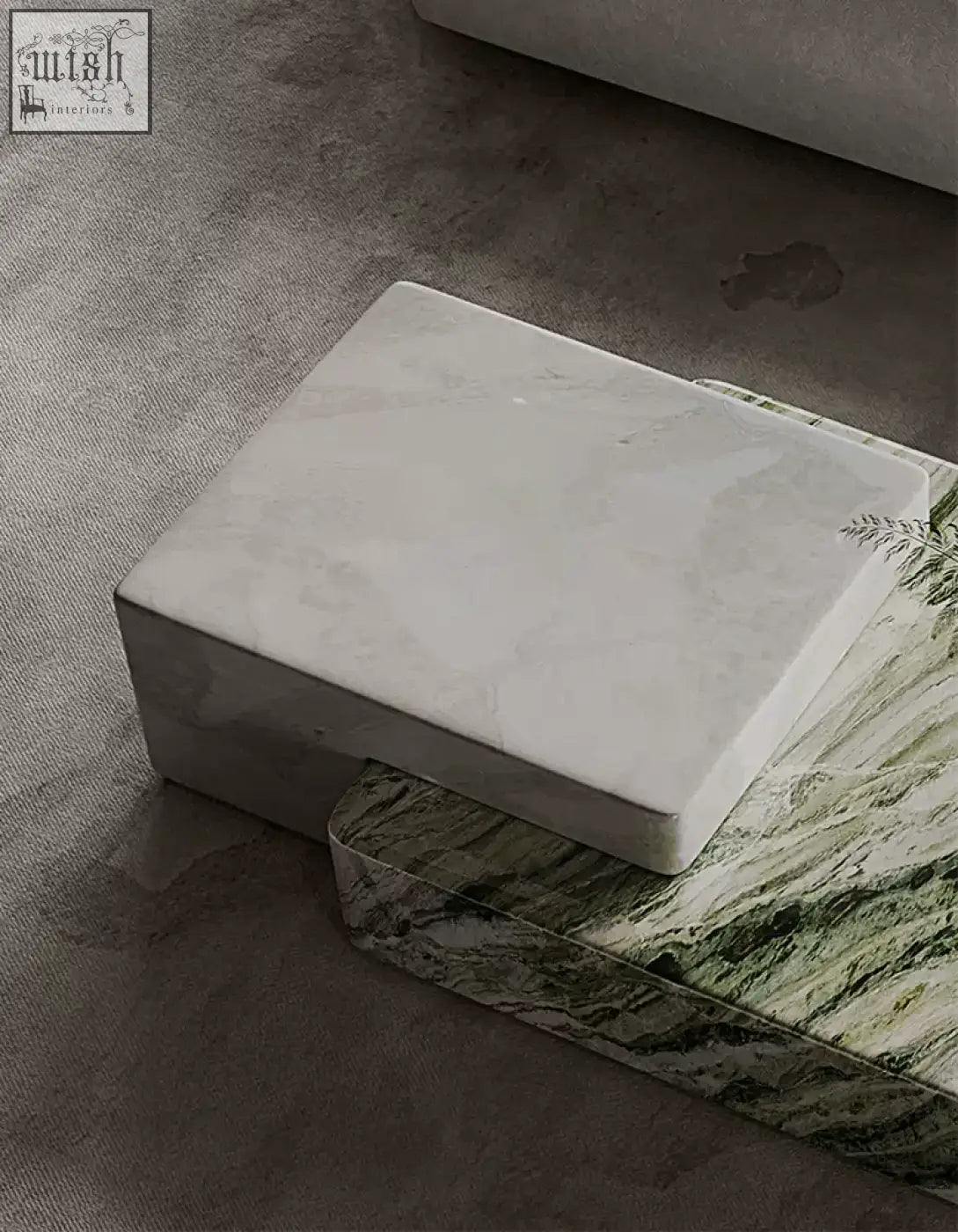 White marble coffee table block with subtle gray veining resting on green and white marbled surface giuli marble coffee table set stone
