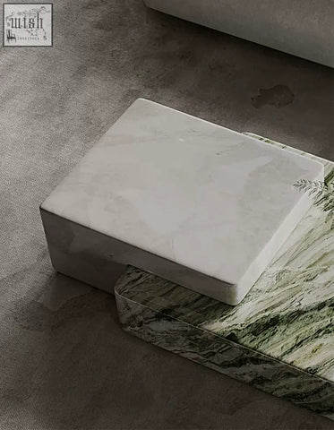 White marble coffee table block with subtle gray veining resting on green and white marbled surface giuli marble coffee table set stone