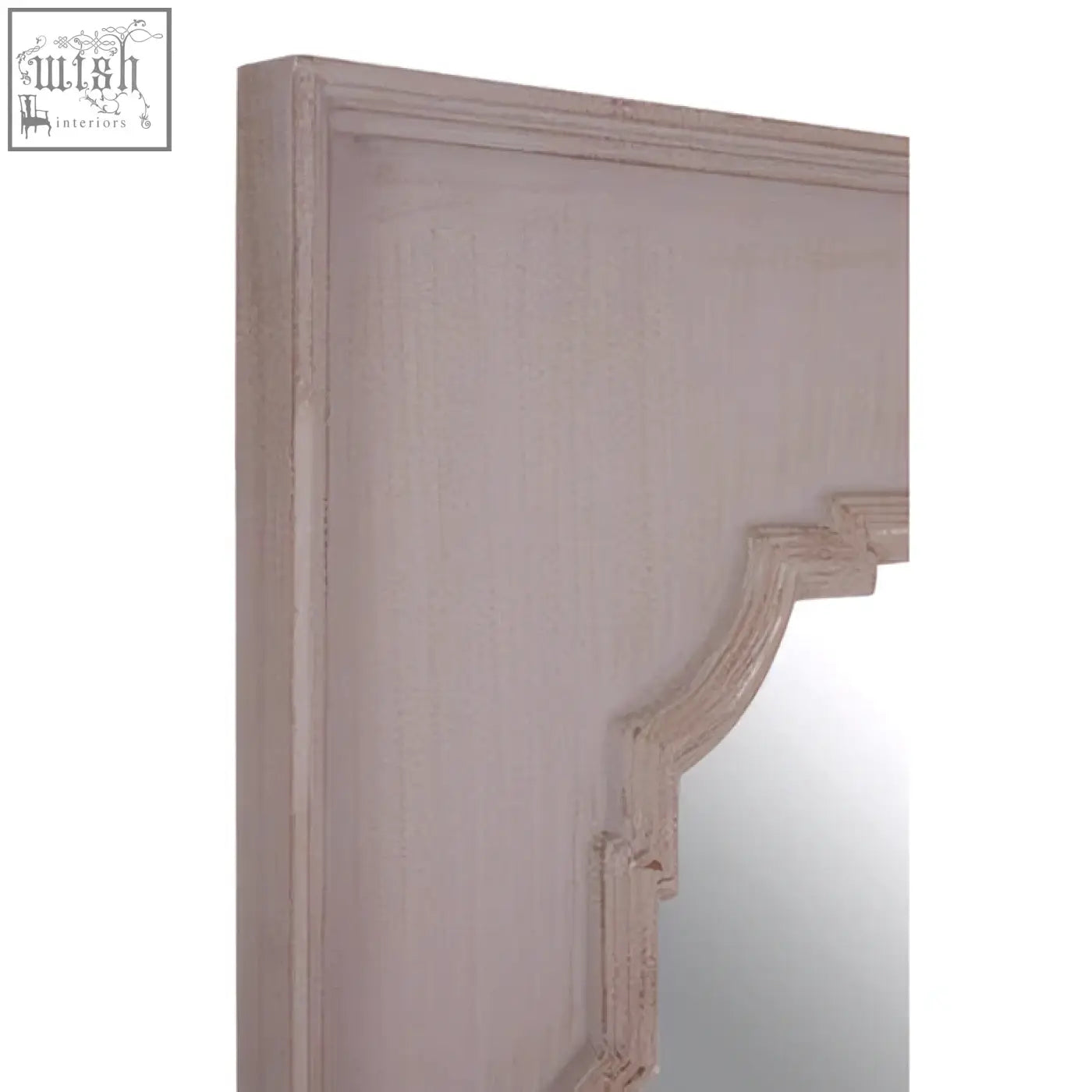 A distressed white wooden gladys fossil grey wall mirror frame with ornate carved detailing on the corner