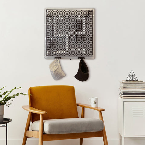 Black and white hexagonal mesh wall organizer with hooks holding beige cap and black hat for go strategy wall game use