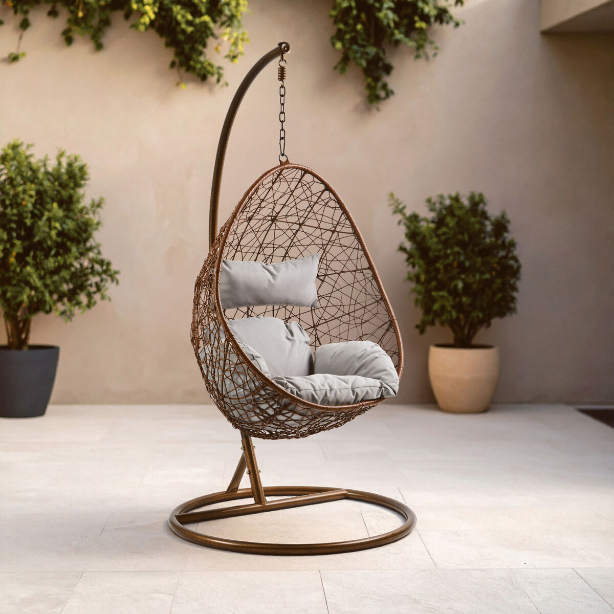 Goa brown rattan hanging chair with brown woven wicker frame and light gray cushioning for comfy seating