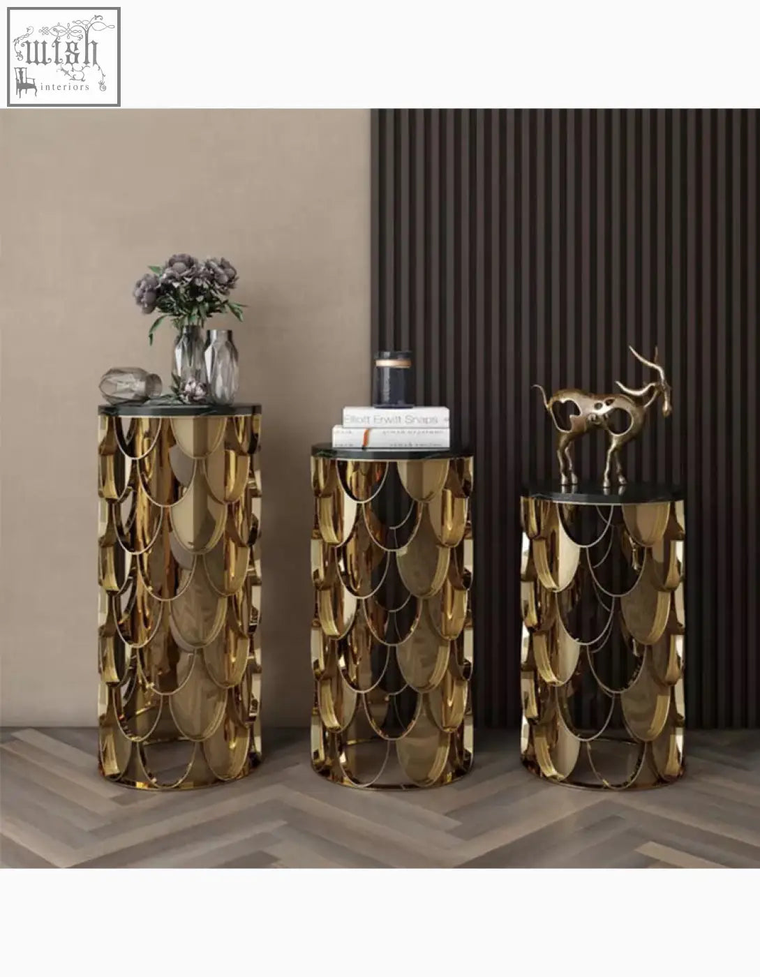 Three golden nesting coffee tables with scale-patterned sides and black marble tops as a gold coffee table set