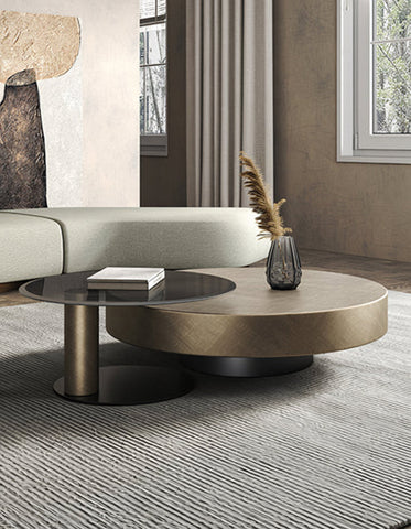 Modern gold coffee table with matte gold top glass surface and sleek black cylindrical base for stylish living room
