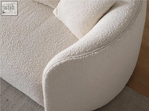 Cream-colored goldie gubi three seater sofa with plush bouclé fabric and rounded armrests in white upholstery