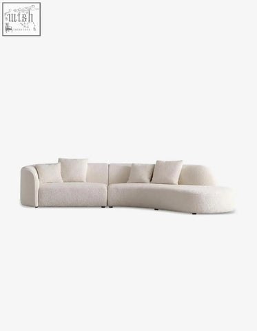 Cream-colored plush goldie gubi three seater sofa with curved boucle upholstery and matching throw pillows